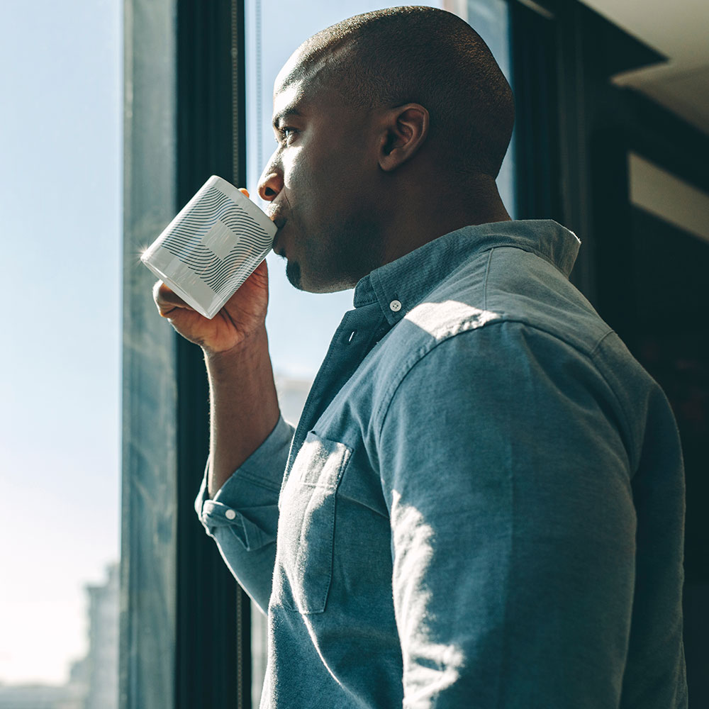 Man sipping coffee while looking out a window