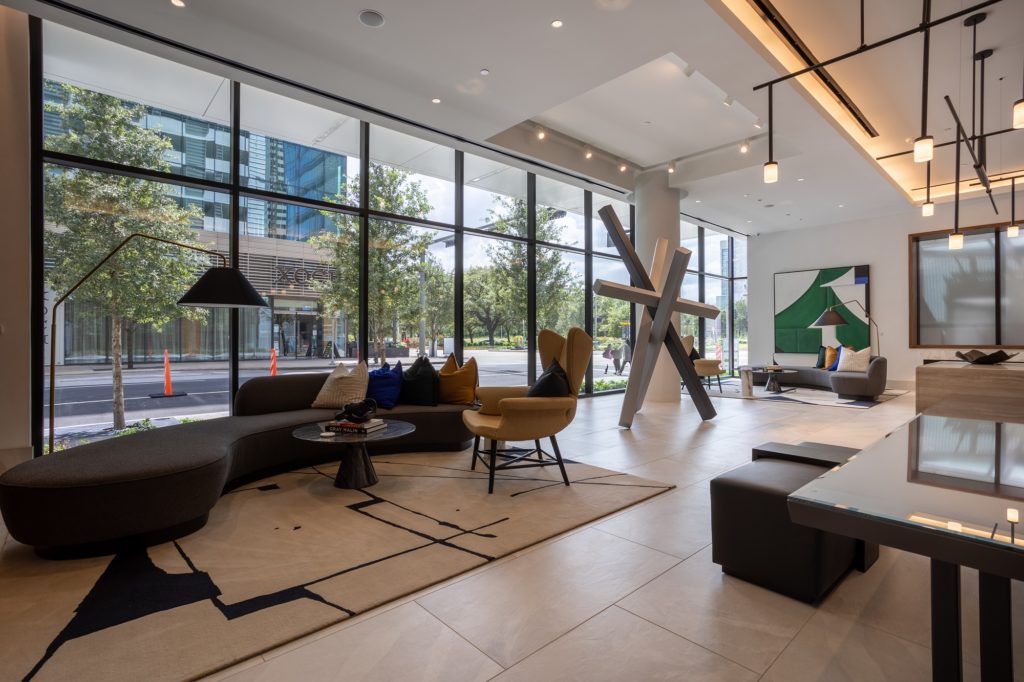 Interior shot of clubhouse with couch and lounge seating, designer lighting, and tile flooring